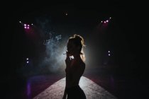 Silhouette einer Frau mit Zigarette vor Projektor — Stockfoto