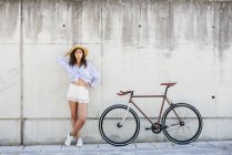 Дівчина позує біля велосипеда — стокове фото