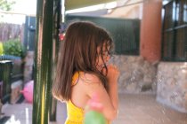 Side view of small brunette girl at backyard — Stock Photo