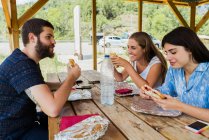 Cheerful friends having meal while traveling — Stock Photo
