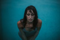 Retrato de mulher no topo do tanque molhado posando na piscina — Fotografia de Stock