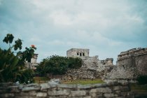 Low angle view of stone historical ruins under gloomy sky in tropics. — Stock Photo