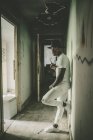 Homem elegante inclinado na parede no corredor abandonado — Fotografia de Stock