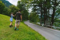 Couple holding hands and walking to road — Stock Photo