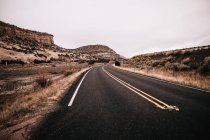 Estrada deserta vazia contra o céu cinzento — Fotografia de Stock