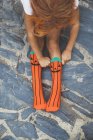 Девушка регулирует оранжевые носки — стоковое фото