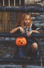 Chica posando con cubo de Halloween - foto de stock
