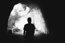 Back view of sihlouette walking in cave tunnel. — Stock Photo