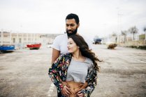Embracing couple in wind looking away — Stock Photo