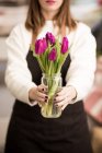 Жінка тримає свіжі рожеві тюльпани в банці — стокове фото