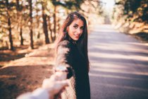 Brunette looking at camera and gesturing at park alley — Stock Photo