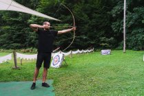 Man practicing archery at countryside — Stock Photo