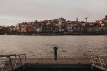 Rückansicht einer Reisenden am Flussufer gegenüber der Altstadt — Stockfoto