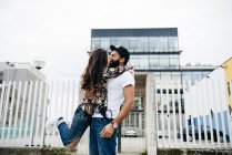 Брюнетка дівчина висить на людину і цілуватися — стокове фото