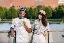 Couple with refreshing drinks looking at camera — Stock Photo