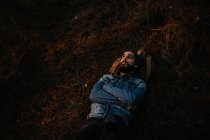 Homem barbudo tendo deitado no chão na floresta — Fotografia de Stock