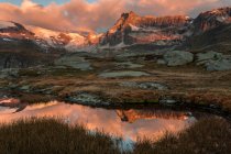 Superficie del lago que refleja montañas soleadas - foto de stock