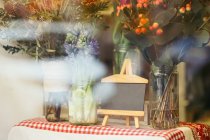 Diferentes buquês naturais em frascos na loja de flores atrás da janela — Fotografia de Stock