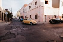 Clássico carro amarelo velho andando nas ruas cena de rua — Fotografia de Stock