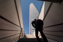 Hombre subiendo las escaleras para darse prisa rascacielos - foto de stock