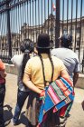 Vista traseira das pessoas que olham para o Palácio do Governo em Lima através de cerca — Fotografia de Stock
