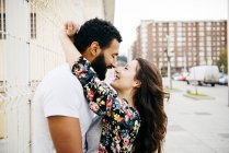 Couple leaning on wall and embracing — Stock Photo