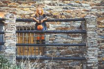 Chica con cesta de calabaza posando en la cerca - foto de stock