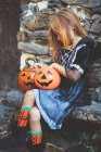 Girl in witch costume sitting on bench — Stock Photo