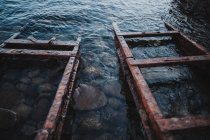Vue à angle bas des vieux rails de fer en eau claire — Photo de stock