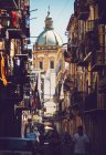 Cathedral facade with sunlit dome seen through narrow street — Stock Photo