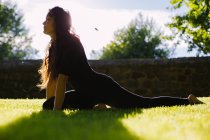 Jeune femme pratiquant le yoga en plein air — Photo de stock