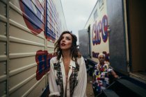 Woman and man behind posing between trailers — Stock Photo
