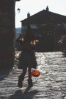 Girl in halloween costume walking street — Stock Photo