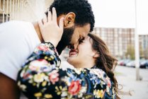 Happy couple embracing and kissing at street — Stock Photo