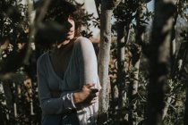 Sinnliches brünettes Mädchen posiert zwischen Bäumen — Stockfoto
