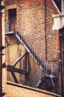 Blick auf altes Backsteingebäude und korrodierte Feuerleiter — Stockfoto