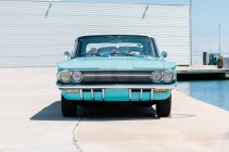 Turquoise vintage car by swimming pool — Stock Photo