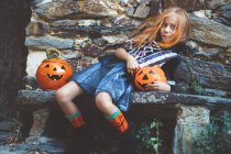 Girl in witch costume on bench — Stock Photo