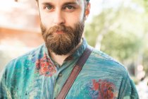 Portrait of bearded man looking at camera at street scene — Stock Photo