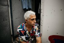 Man with bleached hair looking away — Stock Photo