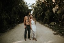 Retrato de casal com dreadlocks posando na estrada tropical — Fotografia de Stock
