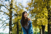 Весела жінка сміється в парку і дивиться — стокове фото