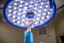 Cropped image of hand adjusting light  in surgery room. — Stock Photo