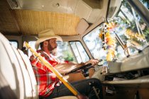 Close up view of bass guitar next to bearded driver in van — Stock Photo