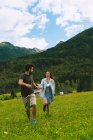 Paar hält Händchen und rennt auf Wiese — Stockfoto