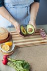 Cozinheiro segurando metades de abacate — Fotografia de Stock