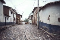 Paved street with rural facade of village houses — Stock Photo