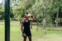 Bodybuilder trinkt Wasser im Park — Stockfoto