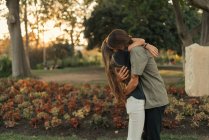 Vue latérale du jeune couple embrassant au parc — Photo de stock