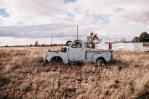 Velho caminhão abandonado no campo árido em dia nublado — Fotografia de Stock